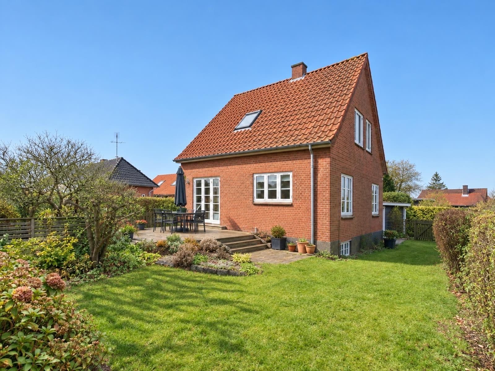 Samme ejendom med klar blå himmel der erstatter den grå