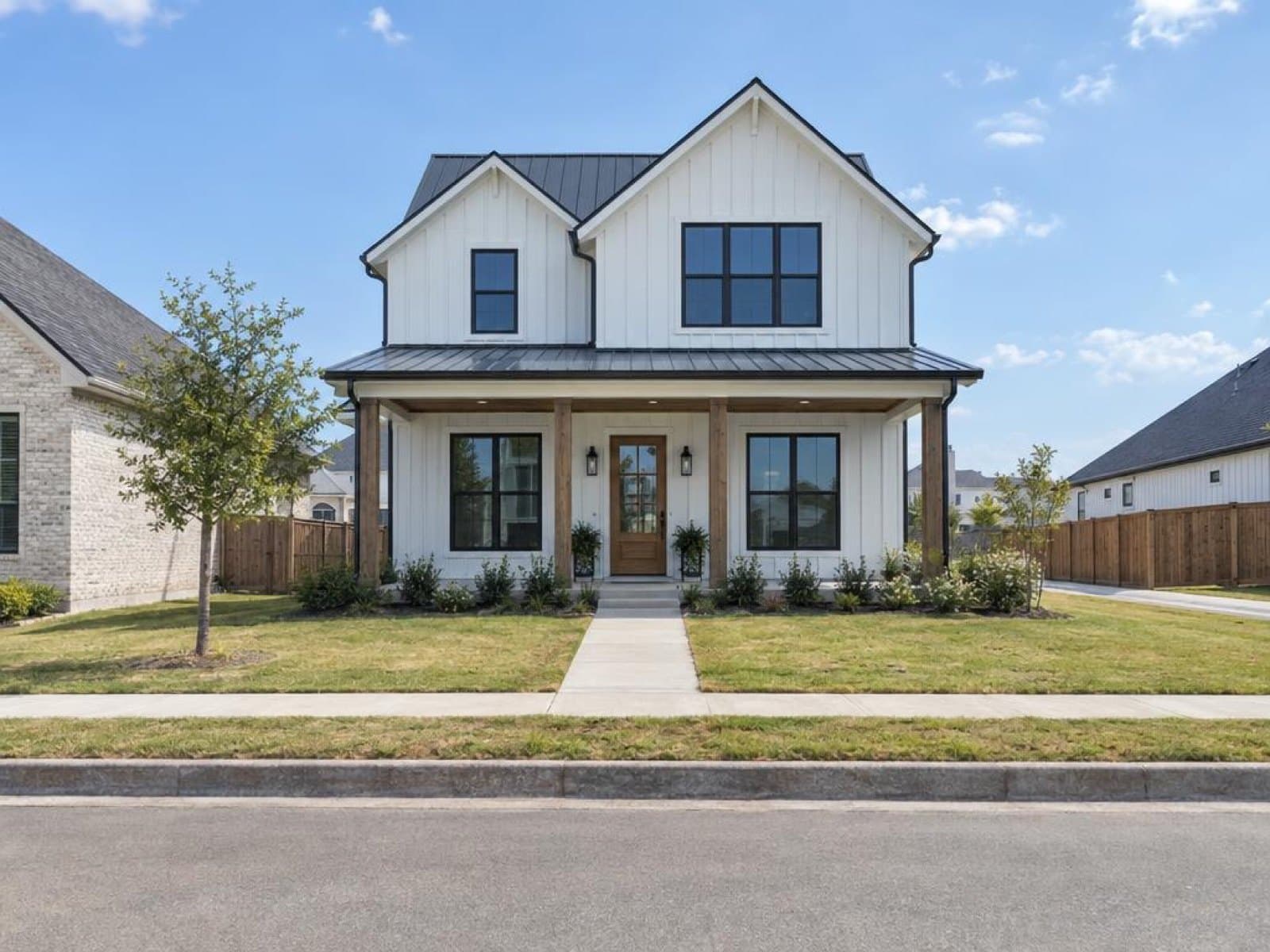 Modern farmhouse with board-and-batten siding, photographed in the daytime with all lights off