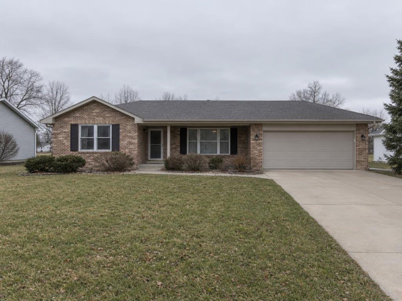 Brick ranch home photographed under a dull overcast sky