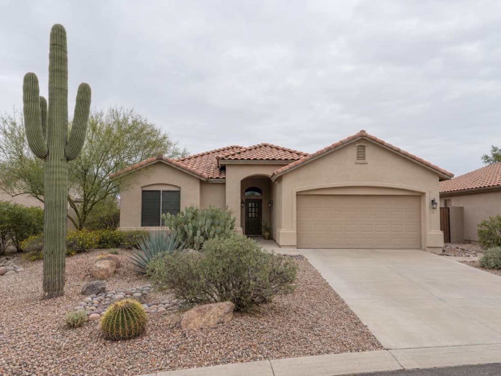 Arizona stucco home under a hazy gray sky