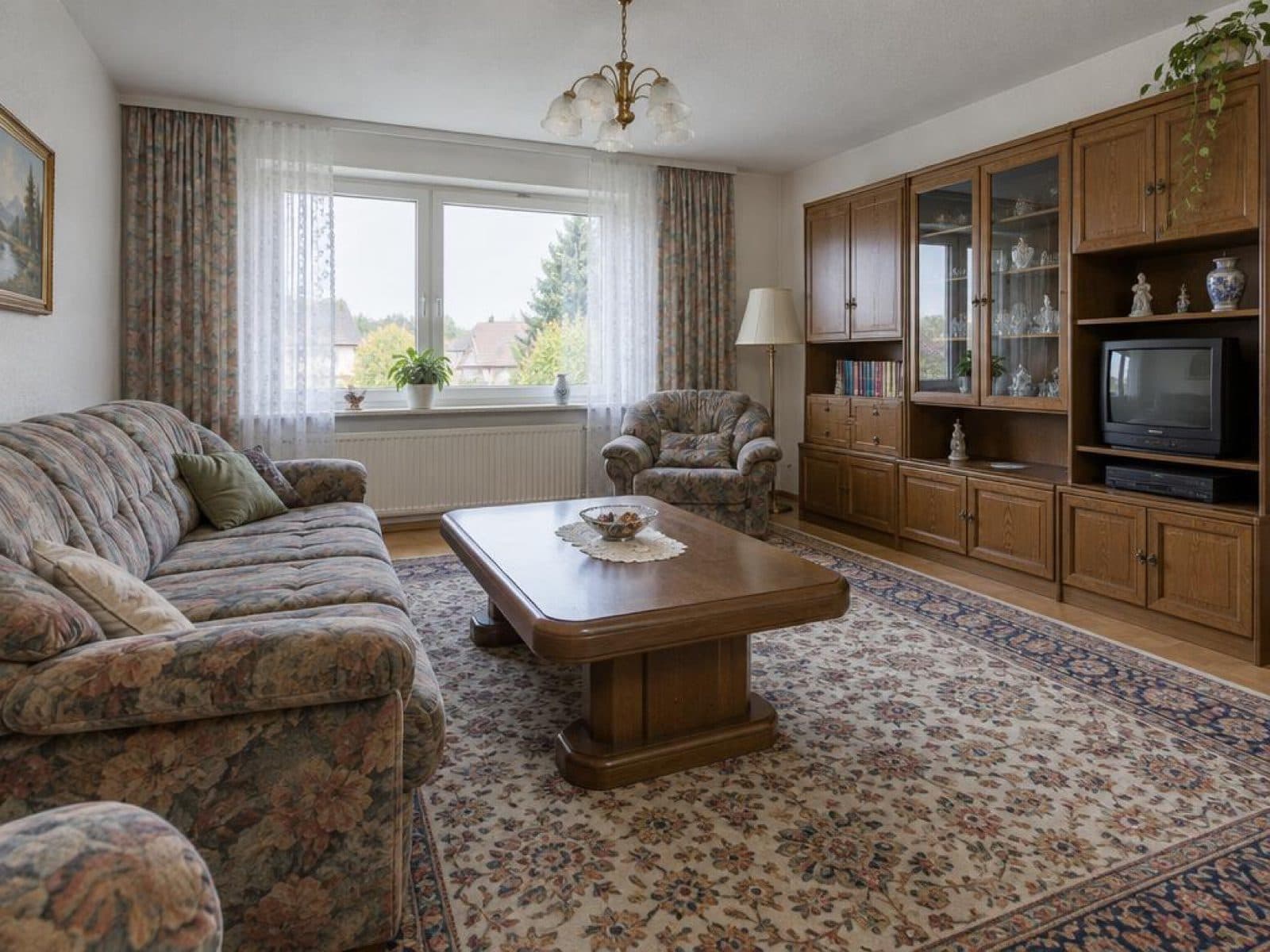 1990s living room with heavy furniture and a large wooden wall unit